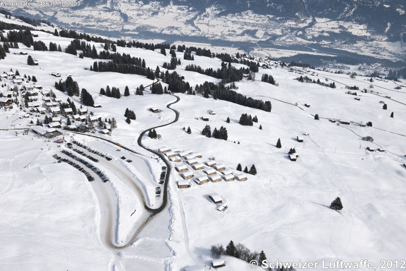 Ferien-Ressort 'Aclas' in der Bildmitte. Links das Dorf Ober-Umrein. Blick nach Osten zum Hinterrhein-Tal.